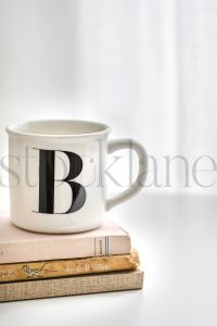 Vertical stock photo of a coffee cup and books