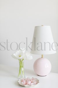 Vertical stock photo of flowers in vase and lamp