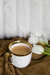 Vertical stock photo of coffee cup and tulips