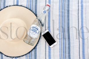 Horizontal Stock photo of beach towel, hat, bottle and phone
