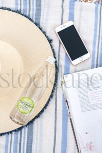 Vertical Stock photo of beach towel, hat, bottle and phone