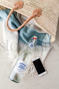 Vertical stock photo of beach basket and phone