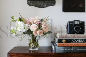 Horizontal stock photo of flowers books and camera
