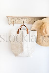 Vertical stock photo of hat, bag, on a coat rack