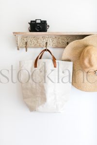 Vertical stock photo of hat, bag, on a coat rack