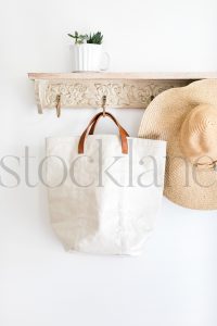 Vertical stock photo of hat, bag, on a coat rack