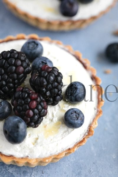 Vertical stock photo of blueberry and blackberry mini pies