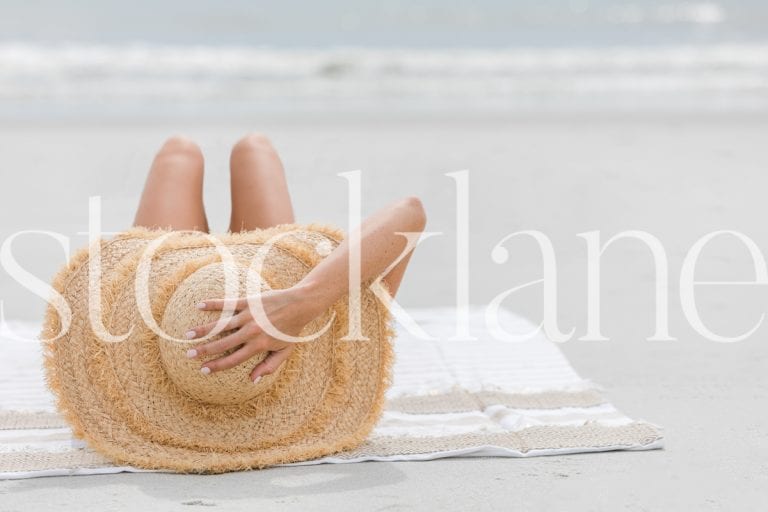 Horizontal stock photo of woman with big hat at the beach