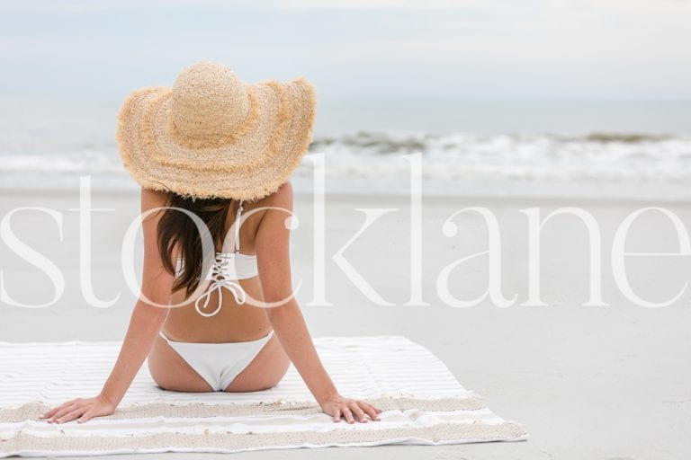 Horizontal stock photo of woman with big hat at the beach