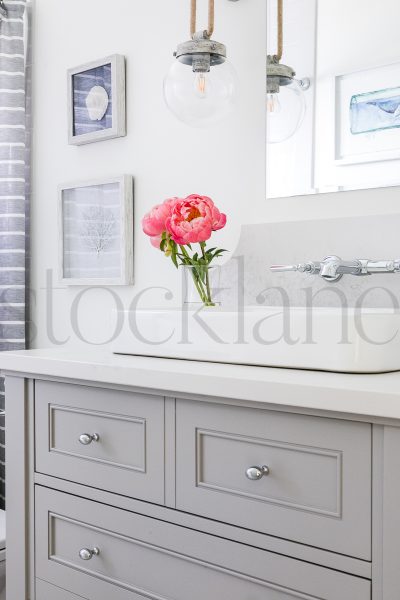 Vertical photo of peonies in a vase in a bathroom