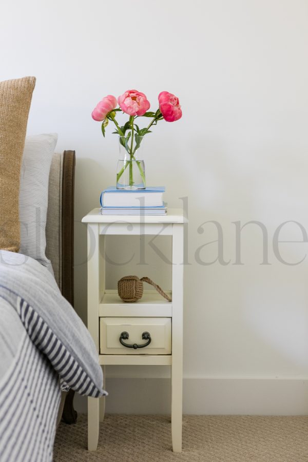 Vertical stock photo of peonies on nightstand