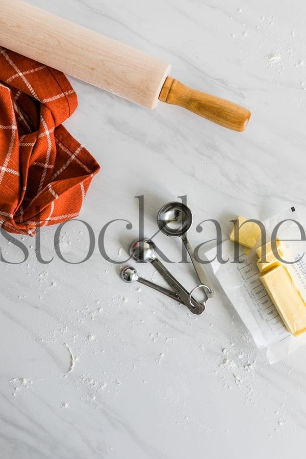 Vertical stock photo of baking utensils, measuring cups, butter and flour, Thanksgiving themed