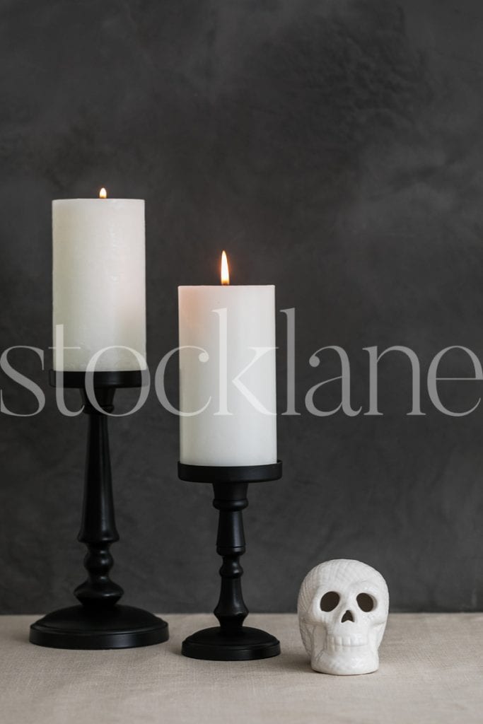 Vertical Halloween stock photo of white candles and skull