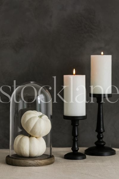 Vertical Halloween stock photo of white candles and white pumpkins