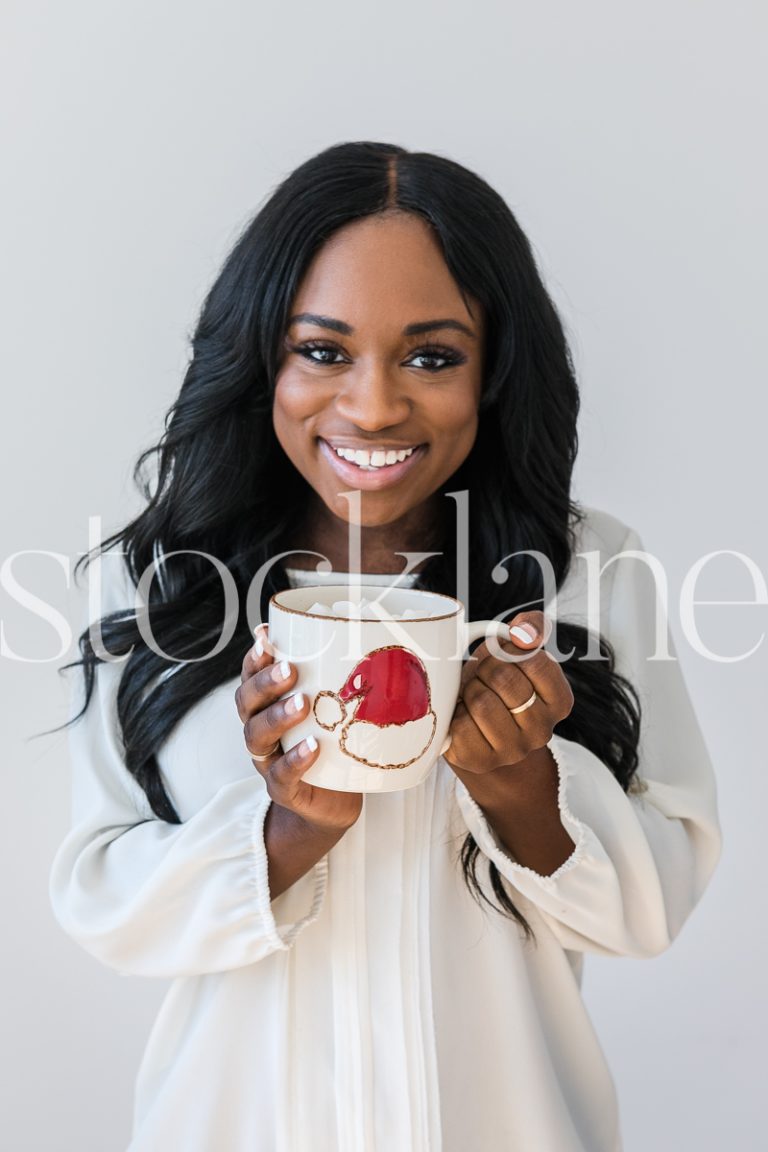 Vertical stock photo of woman holding hot cocoa