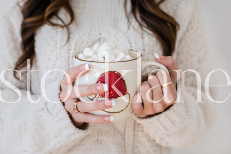 Horizontal stock photo of woman holding hot cocoa cup with marshmallows