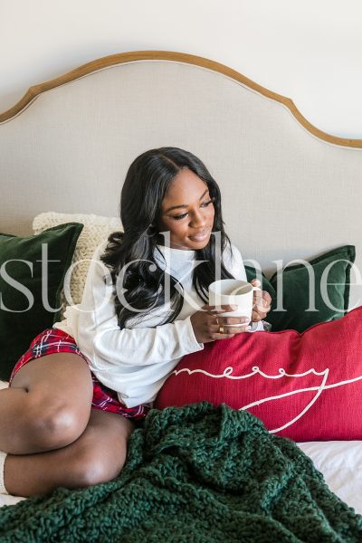 Vertical stock photo of woman having Christmas breakfast in bed