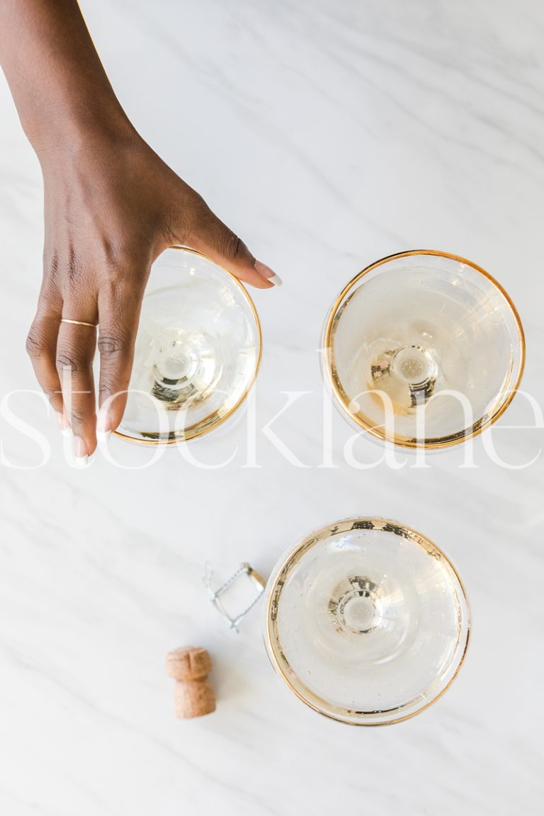 Vertical stock photo of hand with champagne glasses