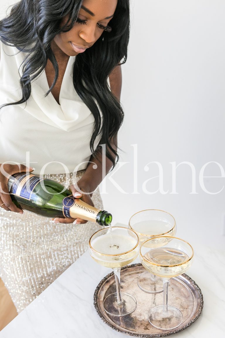 Vertical stock photo of woman pouring champagne