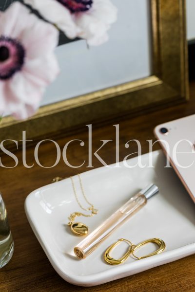 Vertical stock photo of tray with jewelry and phone