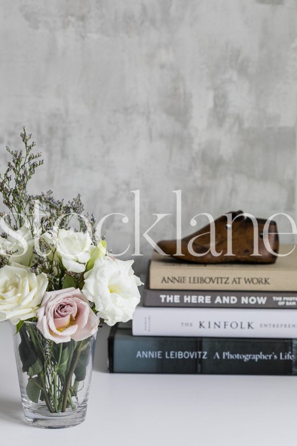 Vertical stock photo of books and flowers