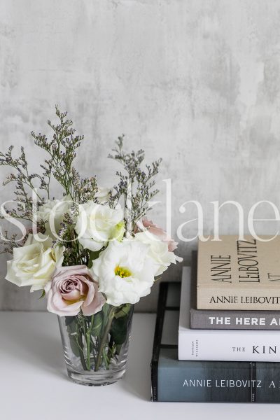 Vertical stock photo of books and flowers