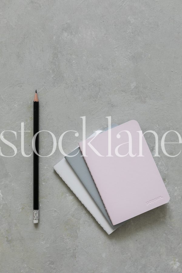 Vertical stock photo of notebooks and pencil