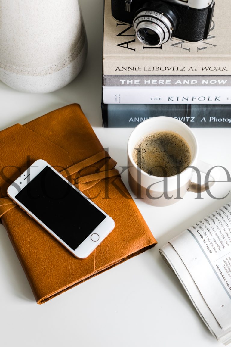 Vertical stock photo of desktop with phone and coffee