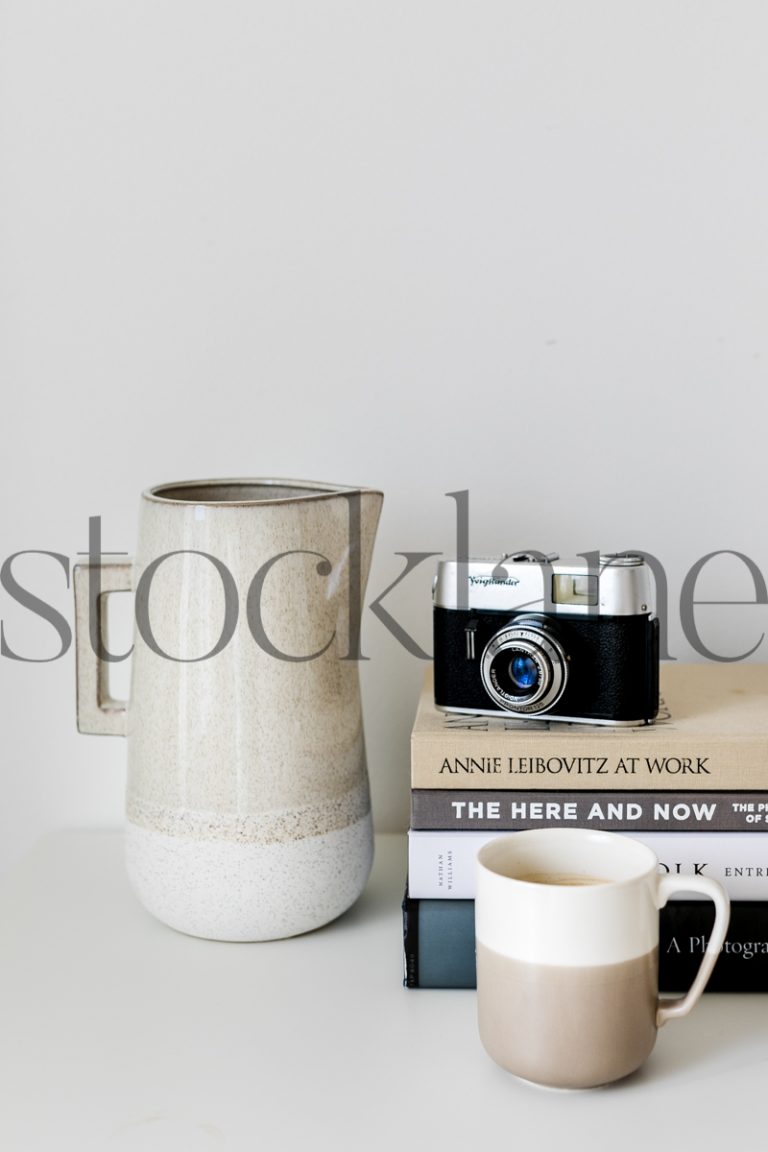 Vertical stock photo of books, jar and coffee mug