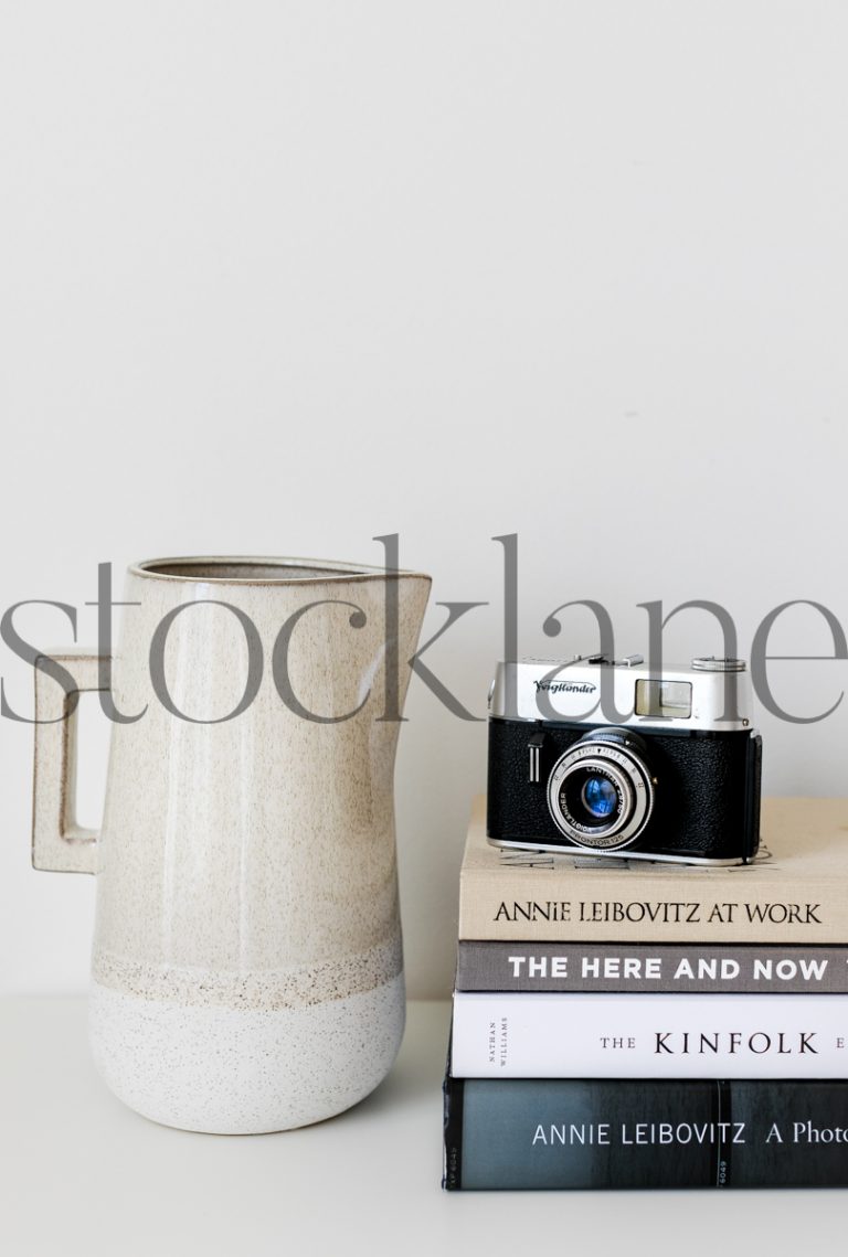 Vertical stock photo of books, jar and camera