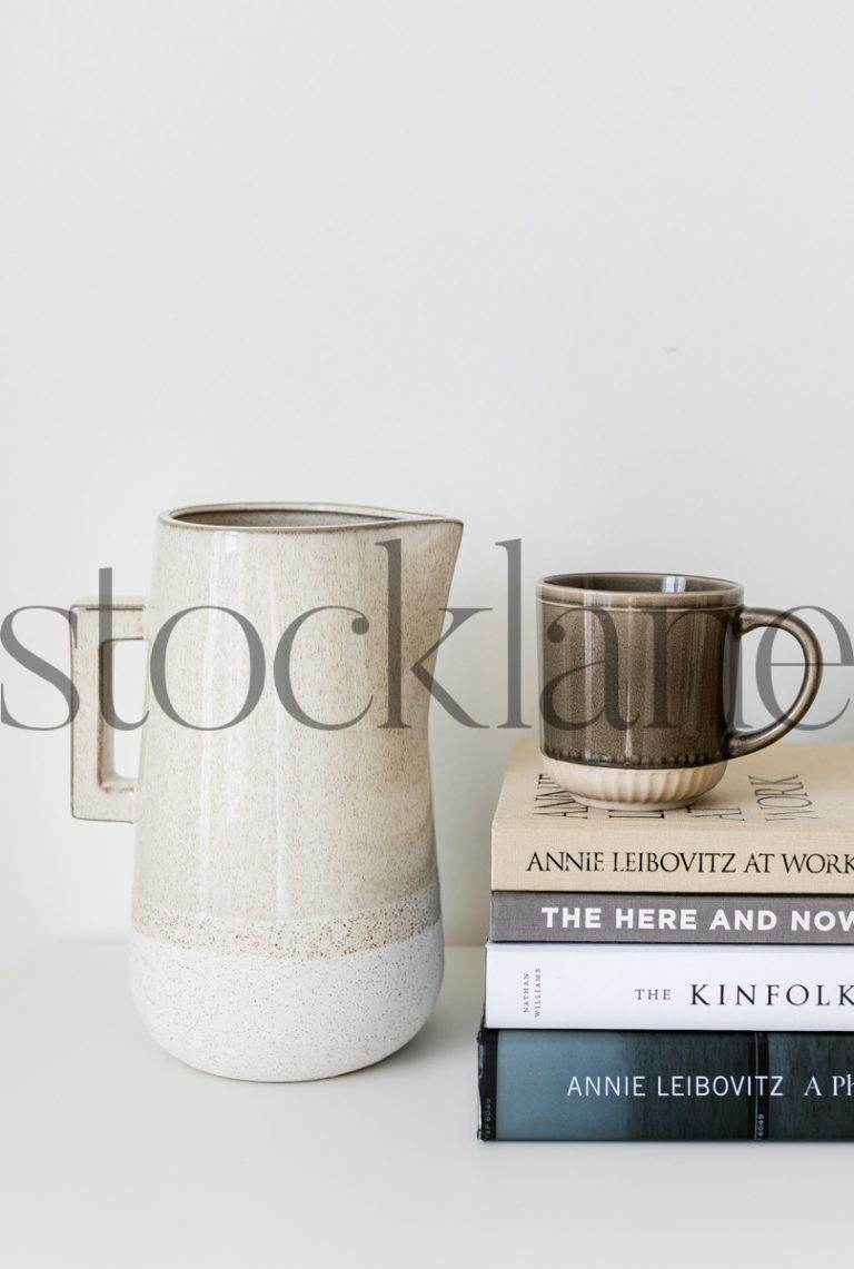 Vertical stock photo of books, jar and coffee mug