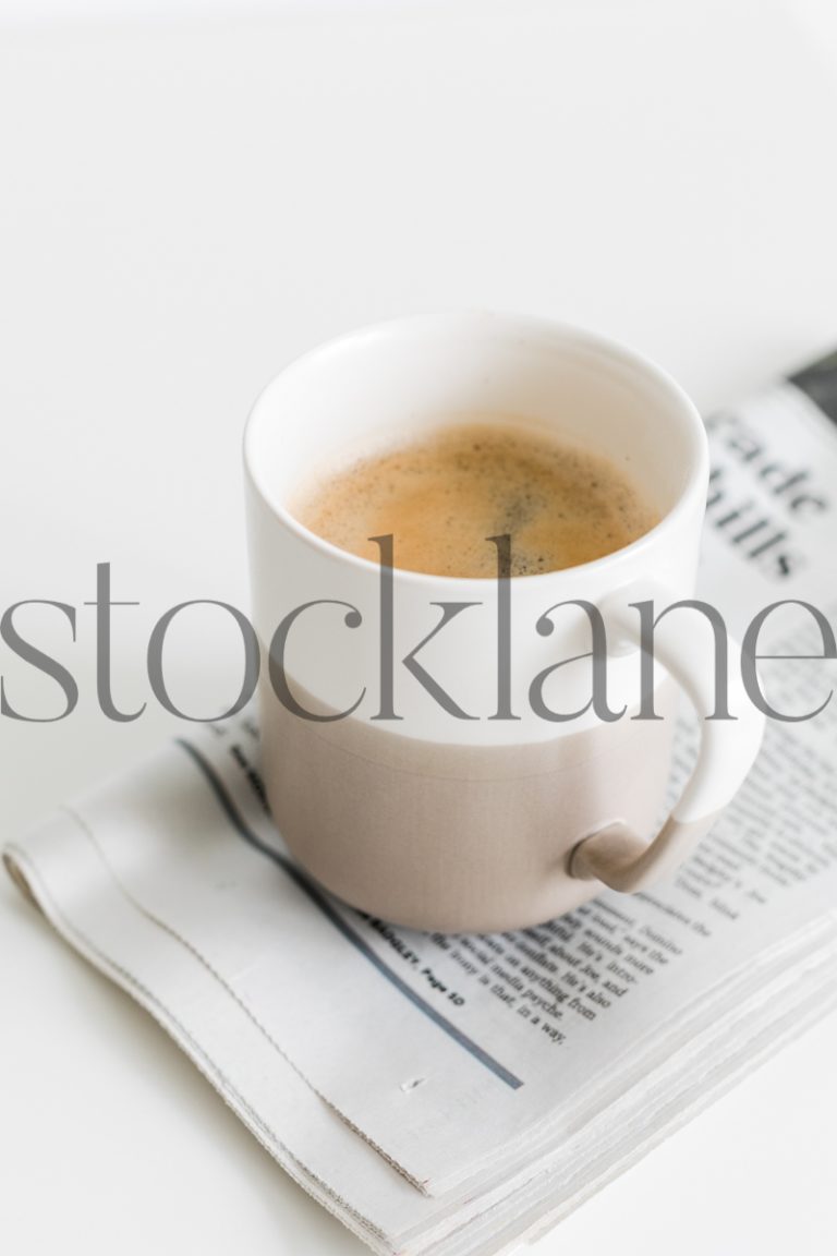 Vertical stock photo of coffee mug and newspaper