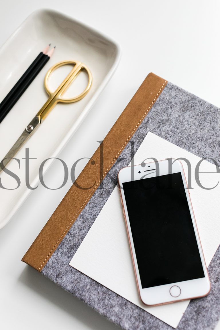 Vertical stock photo of notebook and phone