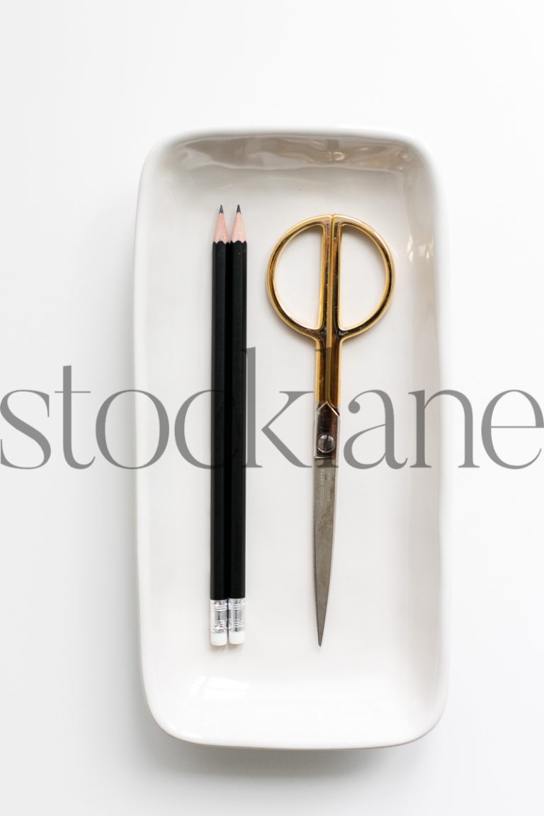 Vertical stock photo of white tray with scissors and pencils