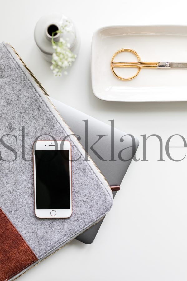 Vertical stock photo of desk with computer and phone