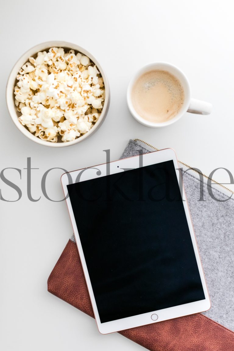 Vertical stock photo of iPad with popcorn and coffee