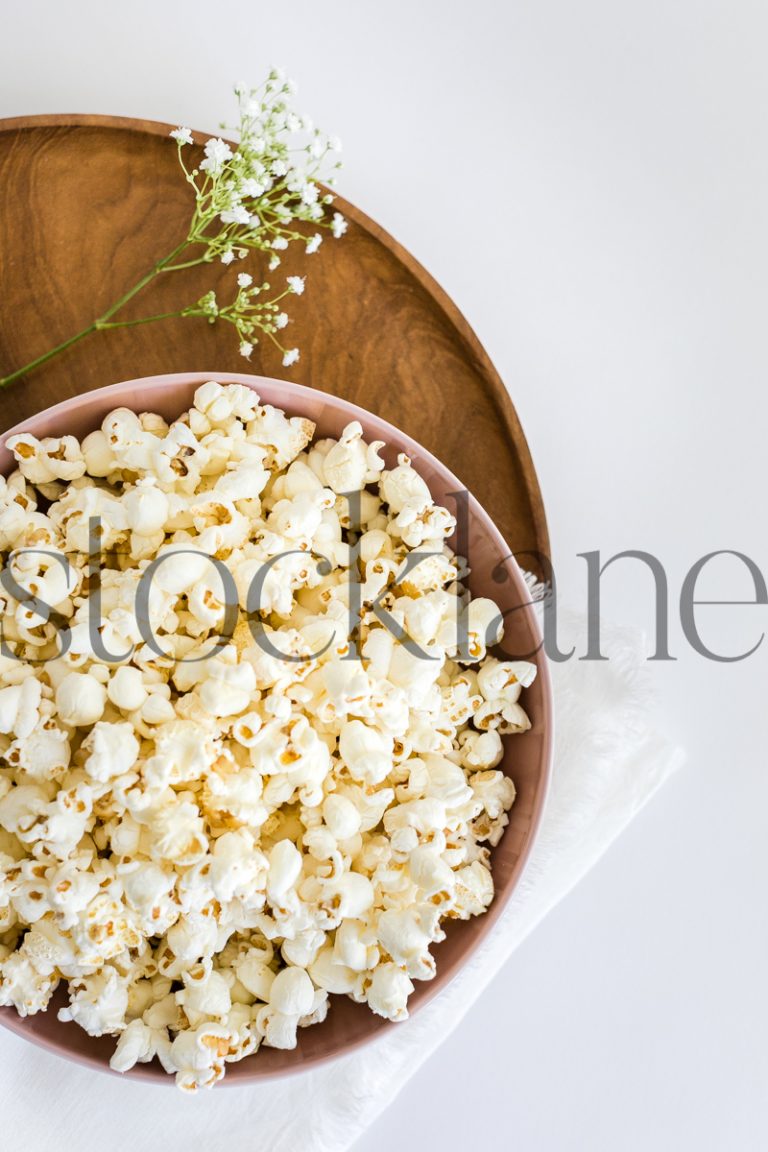 Vertical stock photo of pink bowl with popcorn