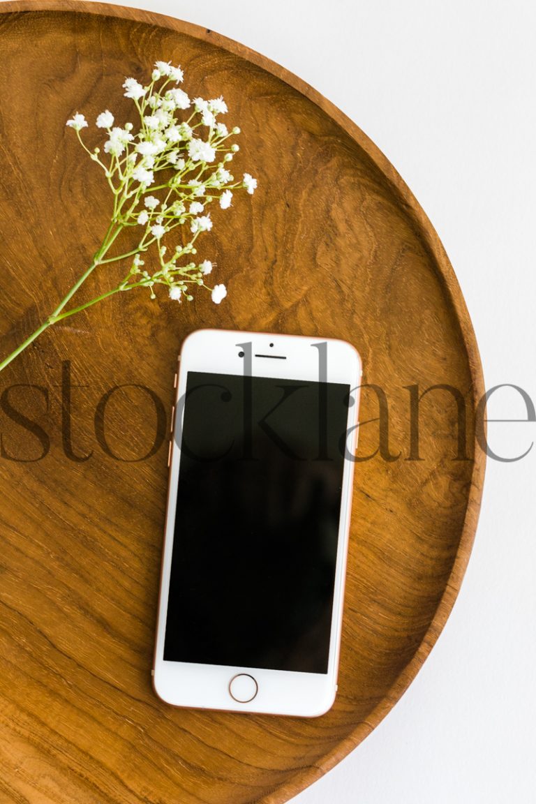 Vertical stock photo of iPhone on wood tray