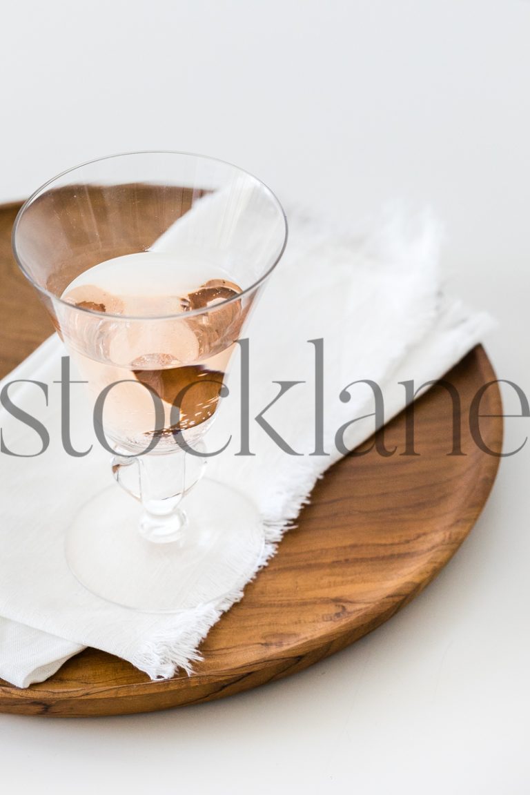 Vertical stock photo of glass of rose wine on a tray