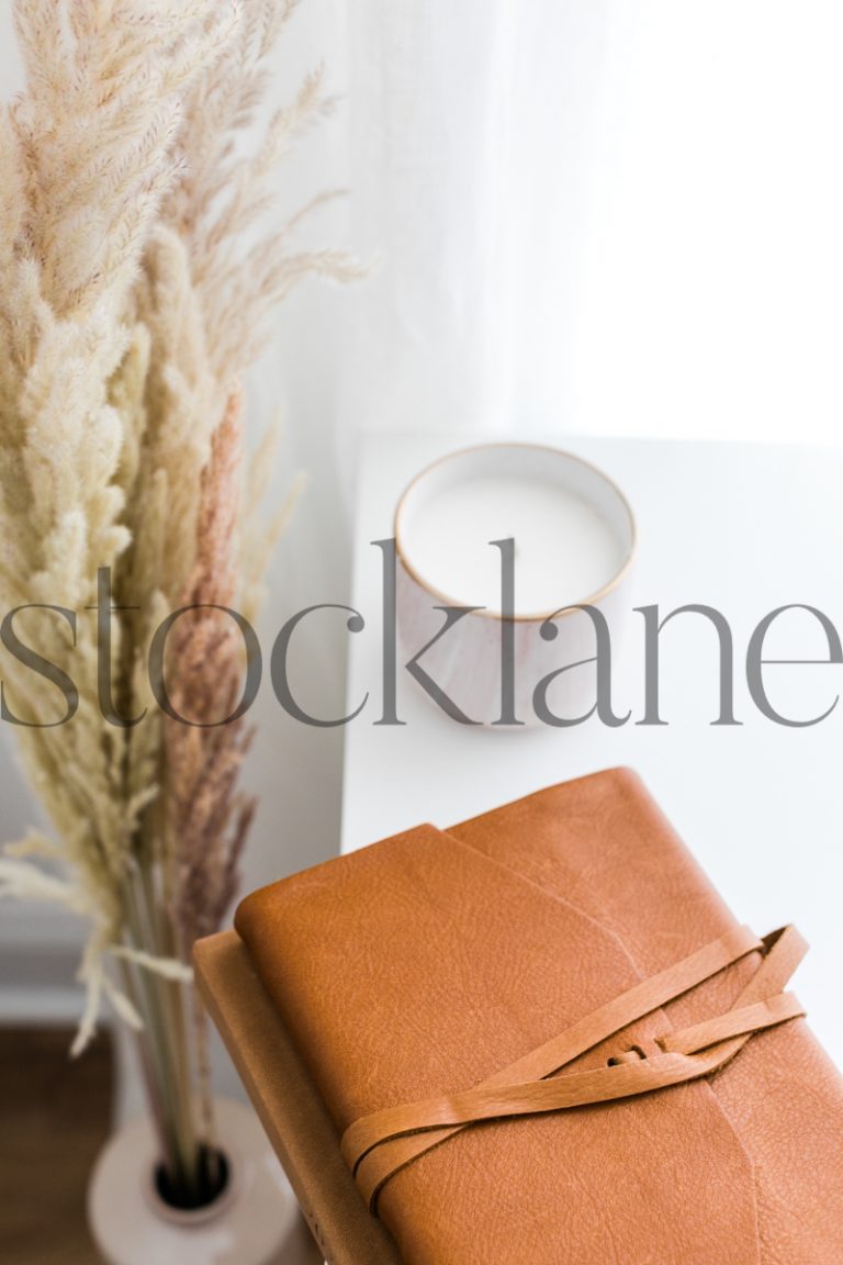 Vertical stock photo of desk with notebook and candle