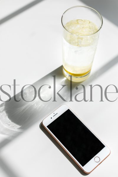 Vertical stock photo of iPhone and lemon water