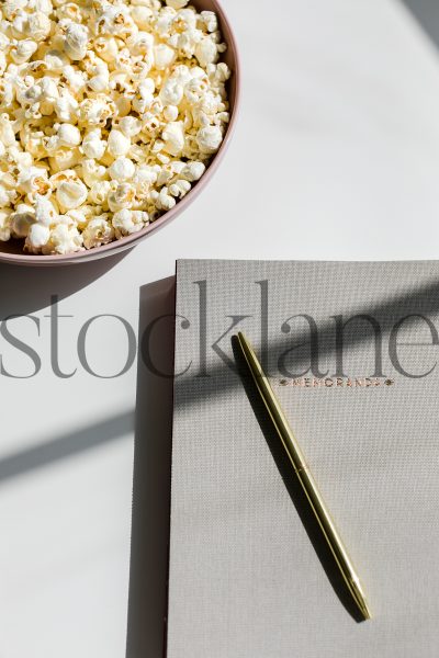 Vertical stock photo of notebook and popcorn