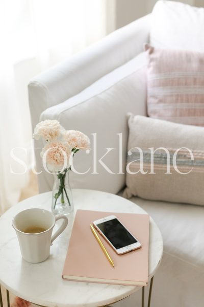 Vertical stock photo of coffee table with coffee and blush flowers