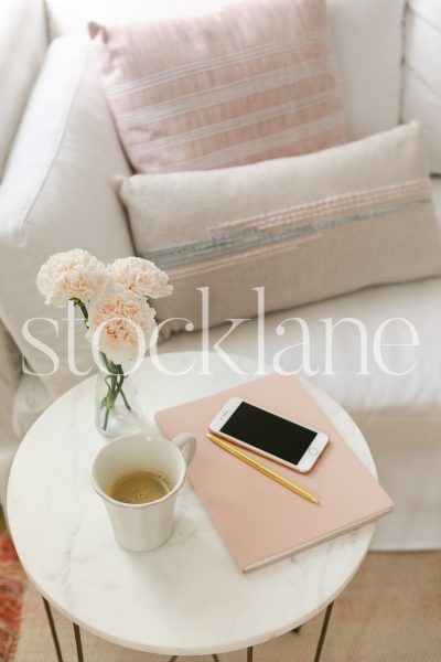 Vertical stock photo of coffee table with coffee and blush flowers