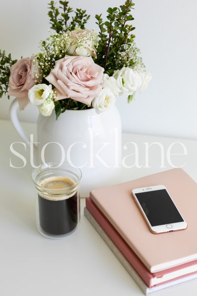 Vertical stock photo of phone and pink notebooks