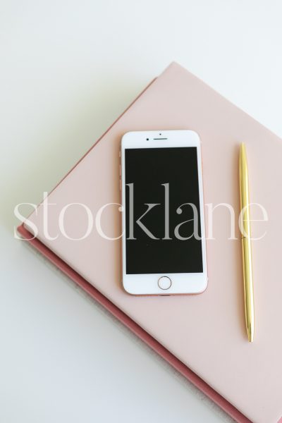 Vertical stock photo of a pink notebook