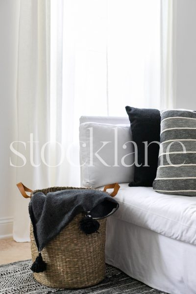 Vertical stock photo of white couch with black pillows