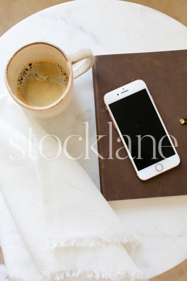 Vertical stock photo of coffee and notebook on table