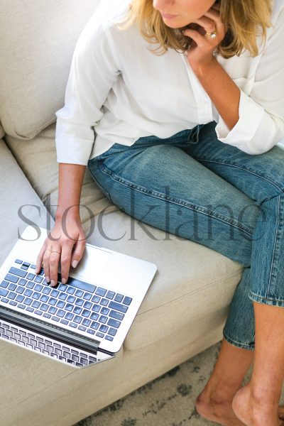 Vertical stock photo of woman working from home with laptop