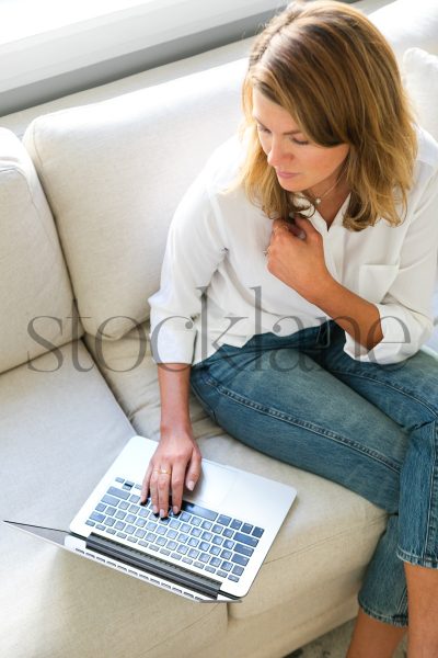 Vertical stock photo of woman working from home with laptop